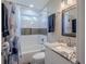 Neat bathroom with tub and shower combo featuring granite countertops and a framed mirror at 1390 Almont Sw Dr, Atlanta, GA 30310