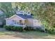 Charming home with dormer windows, a covered front porch and manicured landscaping at 1390 Almont Sw Dr, Atlanta, GA 30310