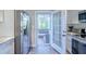 Modern kitchen with stainless steel fridge and an open door to a patio at 1390 Almont Sw Dr, Atlanta, GA 30310