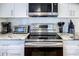 Close-up of modern kitchen appliances including a stainless steel oven and cooktop, complemented by stylish granite countertops at 1390 Almont Sw Dr, Atlanta, GA 30310