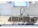 Close-up of a stainless steel kitchen sink set in granite countertops, complemented by white subway tile backsplash at 1390 Almont Sw Dr, Atlanta, GA 30310