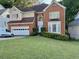 Charming two-story brick and yellow home with well-manicured lawn and attached two-car garage at 350 Rams Way, Tucker, GA 30084