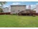 Backyard featuring a large grassy yard, a wooden deck with stairs, and a dark wood fence at 5022 Audubon Pl, Norcross, GA 30093