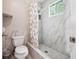 Bathroom with a toilet, walk-in shower, and marble tiling at 5022 Audubon Pl, Norcross, GA 30093