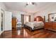 Comfortable bedroom with hardwood floors, a wooden bed frame, and matching dressers at 5022 Audubon Pl, Norcross, GA 30093