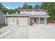 Charming two-story home with stone accents, an attached garage, and a basketball hoop on a spacious driveway at 5022 Audubon Pl, Norcross, GA 30093