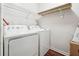 Functional laundry room features a washer, dryer, and shelving, offering a practical space for laundry tasks at 5022 Audubon Pl, Norcross, GA 30093