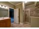 Well-lit bathroom with a glass door shower and a wood vanity at 6213 Arnall Nw Ct, Acworth, GA 30101