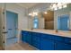 Bright bathroom with blue walls, a large mirror, double sinks, and tile floors at 6213 Arnall Nw Ct, Acworth, GA 30101