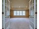Bright, spacious bedroom with large windows, plush carpet, and tray ceilings viewed through a doorway at 6213 Arnall Nw Ct, Acworth, GA 30101