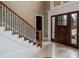 Spacious home foyer featuring tile floors, grand staircase and a beautiful entry door at 6213 Arnall Nw Ct, Acworth, GA 30101