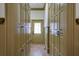 Hallway with abundant cabinet storage, neutral paint and tile flooring leading to a naturally lit door at 6213 Arnall Nw Ct, Acworth, GA 30101