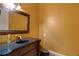 Elegant powder room with a decorative mirror, ornate vanity, and dark fixtures at 6213 Arnall Nw Ct, Acworth, GA 30101