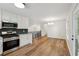 Contemporary kitchen featuring stainless steel appliances, white cabinets, and hardwood flooring at 3343 Mooring Dr, Powder Springs, GA 30127
