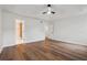A spacious bedroom with wood-look flooring, a ceiling fan, and adjacent closet and bathroom at 3343 Mooring Dr, Powder Springs, GA 30127