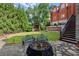 Inviting backyard with manicured lawn, a decorative fire pit, stone patio, and lush greenery surrounding the property at 3863 Streamside Se Dr, Marietta, GA 30067
