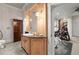 Spacious bathroom with a wooden vanity, stone countertops, and an adjacent exercise room at 3863 Streamside Se Dr, Marietta, GA 30067
