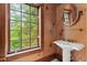 Ornate powder room with pedestal sink and a view of the outside at 3863 Streamside Se Dr, Marietta, GA 30067