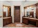 Bathroom featuring a marble shower, dual sinks with wood cabinetry, and decorative mirrors at 3863 Streamside Se Dr, Marietta, GA 30067