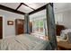 Bedroom featuring a luxurious canopy bed, hardwood floors, and large windows with bright natural light at 3863 Streamside Se Dr, Marietta, GA 30067