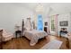 A pastel-colored bedroom, featuring a four-poster bed, an ornate chandelier, and hardwood floors at 3863 Streamside Se Dr, Marietta, GA 30067