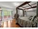 Spacious bedroom featuring hardwood floors, canopy bed, and french doors to the outdoor patio at 3863 Streamside Se Dr, Marietta, GA 30067