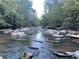 A picturesque creek flows over rocks in a verdant forest, creating a tranquil and scenic landscape at 3863 Streamside Se Dr, Marietta, GA 30067