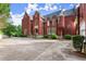 A beautiful, brick stately home with lush landscaping and a circular turret on a sunny day at 3863 Streamside Se Dr, Marietta, GA 30067