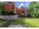 Exterior of a distinguished brick home with multiple levels, lush greenery, and a well-kept lawn at 3863 Streamside Se Dr, Marietta, GA 30067