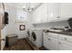 Laundry room with slate tile floors, white cabinets, stainless steel washer and dryer, and a utility sink at 3863 Streamside Se Dr, Marietta, GA 30067