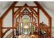 Chandelier and wooden beams highlight the spacious interior of the living room with a tall arched window at 3863 Streamside Se Dr, Marietta, GA 30067
