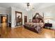 Spacious main bedroom featuring hardwood floors, fireplace, and elegant canopy bed at 3863 Streamside Se Dr, Marietta, GA 30067