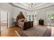 Opulent primary bedroom featuring tray ceilings, an ornate canopy bed, a bay window and a sitting area at 3863 Streamside Se Dr, Marietta, GA 30067