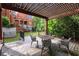 Outdoor patio with a pergola and metal table and chairs, offering a relaxing space with views of the backyard at 3863 Streamside Se Dr, Marietta, GA 30067