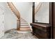 Elegant curved staircase with wooden railing and stone floors, complemented by decorative furniture at 3863 Streamside Se Dr, Marietta, GA 30067