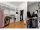 Spacious walk-in closet featuring shelves and racks for clothing, hardwood floor and neutral colored walls at 3863 Streamside Se Dr, Marietta, GA 30067