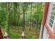 Exterior view showcasing the property's lush, wooded backyard and stone wall at 3863 Streamside Se Dr, Marietta, GA 30067