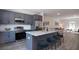 Open kitchen featuring gray cabinets, stainless steel appliances, and an eat-in island with bar stool seating at 4970 Villager Ln, Stone Mountain, GA 30083