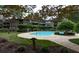 Community pool area surrounded by mature trees, lounge chairs and landscaped areas at 507 Embers Se Dr, Marietta, GA 30067