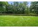 Open green space featuring well-manicured lawn and mature trees in the background at 507 Embers Se Dr, Marietta, GA 30067