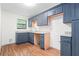 Renovated kitchen featuring blue cabinets, granite countertops, and hardwood floors at 507 Embers Se Dr, Marietta, GA 30067