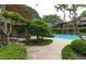 Relaxing community pool with lush landscaping and a pergola-covered seating area at 507 Embers Se Dr, Marietta, GA 30067