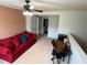 Upstairs loft space features a comfortable red couch, ceiling fan, and a small desk at 1369 Star Water Dr, Lawrenceville, GA 30045