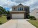 Two-story home with brick facade and attached two-car garage featuring a well-manicured lawn at 1369 Star Water Dr, Lawrenceville, GA 30045
