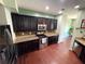 Spacious kitchen featuring dark cabinets, granite countertops, stainless steel appliances, and hardwood floors at 1369 Star Water Dr, Lawrenceville, GA 30045