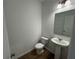 Powder room with a pedestal sink, a toilet, and wood flooring at 2101 Boxwood Circle Se, Conyers, GA 30094