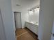 Bathroom featuring a dual sink vanity, modern lighting, white cabinets, and bright neutral paint, floor covered by paper at 2101 Boxwood Circle Se, Conyers, GA 30094