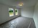 Bedroom with three windows offering natural light and neutral wall color, carpet covered by plastic at 2101 Boxwood Circle Se, Conyers, GA 30094