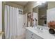This bathroom features a shower-tub combo with a white shower curtain and a single sink vanity at 4876 Sara Creek Way, Sugar Hill, GA 30518