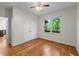 Bright bedroom features hardwood floors, a ceiling fan, and a window with views of a wooded area at 4876 Sara Creek Way, Sugar Hill, GA 30518